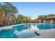 Community pool with surrounding sun deck, lounge chairs, and beautiful desert landscaping at 27000 N Alma School Pkwy # 1033, Scottsdale, AZ 85262