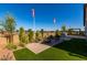 Backyard offers a cozy seating area, artificial turf, and desert landscaping at 27647 N 176Th Dr, Surprise, AZ 85387