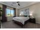 Serene bedroom with a comfortable bed, stylish decor, and a large window offering scenic views at 27647 N 176Th Dr, Surprise, AZ 85387