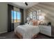 A cozy bedroom with a decorative bed, natural light, and tasteful decor at 27647 N 176Th Dr, Surprise, AZ 85387