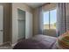 Bedroom featuring a sliding closet door and a bright window with stylish curtains at 27647 N 176Th Dr, Surprise, AZ 85387