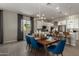 Elegant dining room area featuring modern lighting, a table set for a meal, and seamless flow to kitchen at 27647 N 176Th Dr, Surprise, AZ 85387