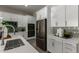 This kitchen features white cabinets, stainless steel appliances, quartz countertops, and decorative tile backsplash at 27647 N 176Th Dr, Surprise, AZ 85387