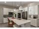 Bright kitchen features white cabinets, stainless steel appliances, quartz countertops, and an eat-in island at 27647 N 176Th Dr, Surprise, AZ 85387