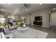 Open-concept living room featuring neutral tones, modern furniture, and seamless flow to the kitchen at 27647 N 176Th Dr, Surprise, AZ 85387