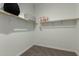 A walk-in closet with wood shelving, storage and ample space for organization at 27647 N 176Th Dr, Surprise, AZ 85387