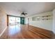 Open living room showcasing wood floors, a ceiling fan, a brick wall accent, and sliding glass doors to the exterior at 2933 W Del Mar Ln, Phoenix, AZ 85053