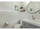 Charming half-bath features a grey vanity, round mirror, framed artwork and a modern sink faucet at 3222 E Cortez St, Phoenix, AZ 85028