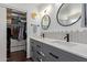 Bathroom vanity featuring double sinks, modern fixtures, and a large walk-in closet at 3222 E Cortez St, Phoenix, AZ 85028
