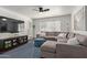 Cozy living room with gray sectional sofa, blue accents, large windows, and dark laminate flooring at 3222 E Cortez St, Phoenix, AZ 85028