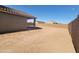 A spacious backyard displaying a covered patio and block perimeter wall at 329 S San Christo Ln, Casa Grande, AZ 85194