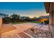 A landscaped backyard with mature trees, artificial turf and a stone-laid patio at 3417 E Los Gatos Dr, Phoenix, AZ 85050