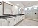 Bright bathroom features a double sink vanity with black countertop and a glass-enclosed shower with tiled walls at 3417 E Los Gatos Dr, Phoenix, AZ 85050
