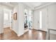 Bright foyer featuring wood floors, a view to an office and a bathroom, and a white paneled front door at 3417 E Los Gatos Dr, Phoenix, AZ 85050