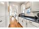 Galley kitchen with black countertops, white cabinetry, and hardwood flooring, providing ample space for cooking at 3417 E Los Gatos Dr, Phoenix, AZ 85050