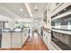 Bright open-concept kitchen featuring white cabinets, a center island, stainless appliances, and wood flooring at 3417 E Los Gatos Dr, Phoenix, AZ 85050