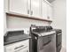 Convenient laundry room features modern gray washer and dryer sets with upper cabinets and counter space at 3417 E Los Gatos Dr, Phoenix, AZ 85050