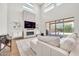 Elegant living room featuring high ceilings, a modern fireplace, sliding glass doors, and natural light at 3417 E Los Gatos Dr, Phoenix, AZ 85050