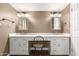 Bathroom with double sinks, white cabinets, and a vanity area with a chair, with decorative mirrors and light fixtures at 3512 S Elm St, Tempe, AZ 85282