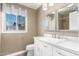 Bathroom with a white vanity, sink, mirror, toilet, and window with a view of the outside at 3512 S Elm St, Tempe, AZ 85282