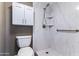 This bathroom features a marble shower with a built-in shelves, a toilet, and a mounted storage cabinet at 3512 S Elm St, Tempe, AZ 85282