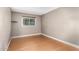 Bedroom featuring wood floors, base molding, and a window with blinds, offering natural light and privacy at 3512 S Elm St, Tempe, AZ 85282