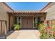 Inviting front entry with double doors, tiled overhang, colorful flowering plants, and brick pavers at 3512 S Elm St, Tempe, AZ 85282