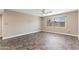 Bright, neutral toned living room offering a ceiling fan, updated trim and oversized window at 3512 S Elm St, Tempe, AZ 85282