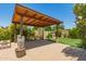 Covered patio with brick flooring, desert landscaping, and artificial turf area at 3512 S Elm St, Tempe, AZ 85282