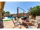 Inviting backyard with a pool, fire pit and lounge seating, ideal for outdoor entertainment and leisure at 3742 E Sandy Way, Gilbert, AZ 85297
