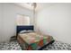 Simple bedroom with a colorful comforter, black and white tile floor, and lots of natural light at 3742 E Sandy Way, Gilbert, AZ 85297