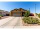 Tan home with a desert landscape, including cactus and flowering bushes, a 2 car garage, and a concrete driveway at 3742 E Sandy Way, Gilbert, AZ 85297