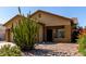 Tan home with desert landscape with large cactus, rocks, and flowering bushes, as well as a 2 car garage at 3742 E Sandy Way, Gilbert, AZ 85297