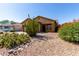 Tan home with a desert landscape including cactus and bright flowering bushes, and a two car garage at 3742 E Sandy Way, Gilbert, AZ 85297
