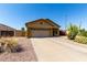 Tan home with a desert landscape, including cactus and flowering bushes, a 2 car garage, and a concrete driveway at 3742 E Sandy Way, Gilbert, AZ 85297