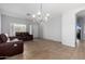 Open living room with tile flooring, chandelier lighting, and a leather sofa and loveseat set at 3742 E Sandy Way, Gilbert, AZ 85297