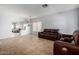 Open living room with tile flooring, chandelier lighting, and a leather sofa and loveseat set at 3742 E Sandy Way, Gilbert, AZ 85297