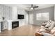 Living room featuring a fireplace, tiled floors, a ceiling fan, modern decor, and a leather sofa at 3742 E Sandy Way, Gilbert, AZ 85297