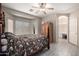 Comfortable main bedroom with an arched doorway to the bathroom, large windows, and unique flooring at 3742 E Sandy Way, Gilbert, AZ 85297