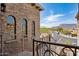 Stunning stone exterior featuring arched windows and wrought-iron balcony with sweeping views of the desert landscape at 4366 S Avenida De Angeles --, Gold Canyon, AZ 85118