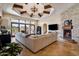 Elegant living room featuring a stone fireplace, beamed ceilings, tile floors, and a large sectional sofa at 4366 S Avenida De Angeles --, Gold Canyon, AZ 85118