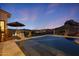 Backyard pool with desert views and umbrella at dusk at 4366 S Avenida De Angeles --, Gold Canyon, AZ 85118