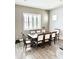 Dining room with a large window, hardwood flooring, and an elegant wooden dining table with seating for eight at 4956 S Leisure Way, Gilbert, AZ 85298