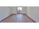 View of an empty bedroom with wood flooring, baseboards, and a sliding glass door to the outside at 5757 W Eugie Ave # 2068, Glendale, AZ 85304