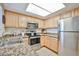Galley kitchen featuring stainless steel appliances, granite countertops, and light wood cabinets at 5757 W Eugie Ave # 2068, Glendale, AZ 85304