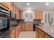 Well-lit kitchen featuring tan cabinets, modern appliances, and granite countertops at 5919 W Straight Arrow Ln, Phoenix, AZ 85083