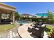 Relaxing backyard featuring a sparkling pool, covered patio, comfortable seating, and lush greenery at 5957 W Robin Ln, Glendale, AZ 85310