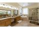 Spacious bathroom with double sinks, granite counters, a soaking tub, and a separate glass shower at 5957 W Robin Ln, Glendale, AZ 85310