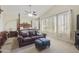 Serene bedroom with a sitting area, a canopy bed, plantation shutters, and plenty of natural light at 5957 W Robin Ln, Glendale, AZ 85310