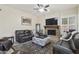 Relaxing living room with a stone fireplace, TV, leather sofas, and a decorative rug at 5957 W Robin Ln, Glendale, AZ 85310
